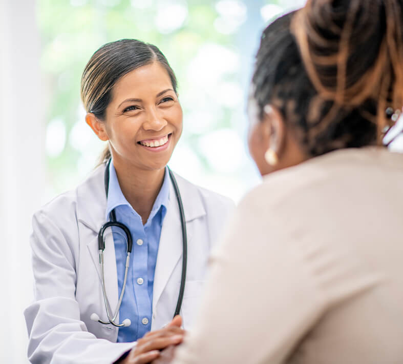 female nurse smiling at a patient she is helping