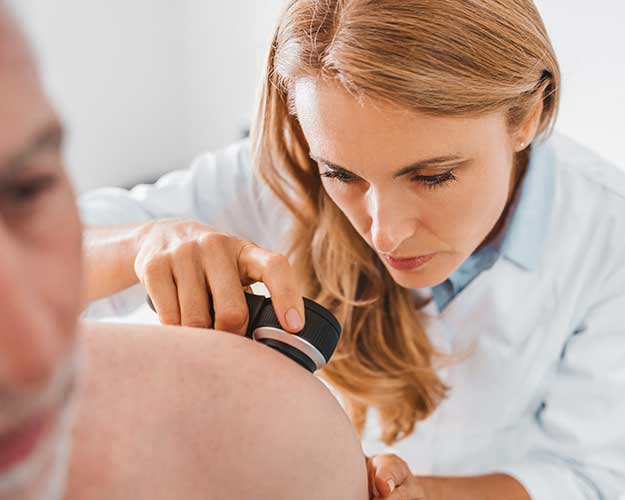 Doctor performing a skin cancer check on patient