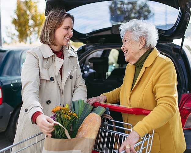 younger woman helping a senior woman with shopping