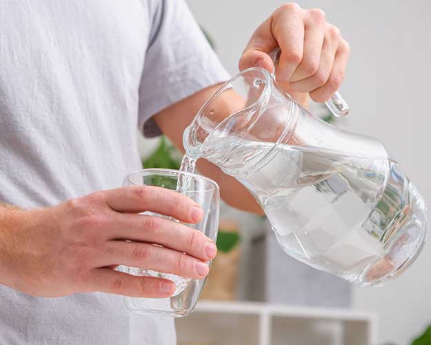 Man pouring a pitcher of water