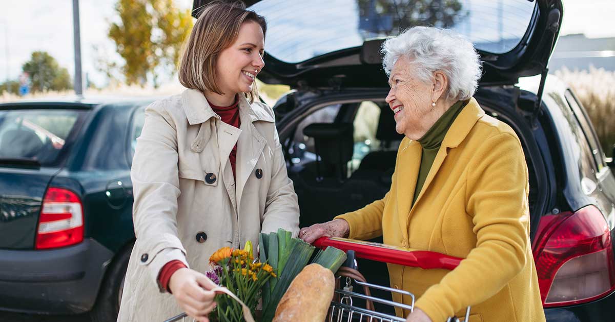 younger woman helping a senior woman with shopping
